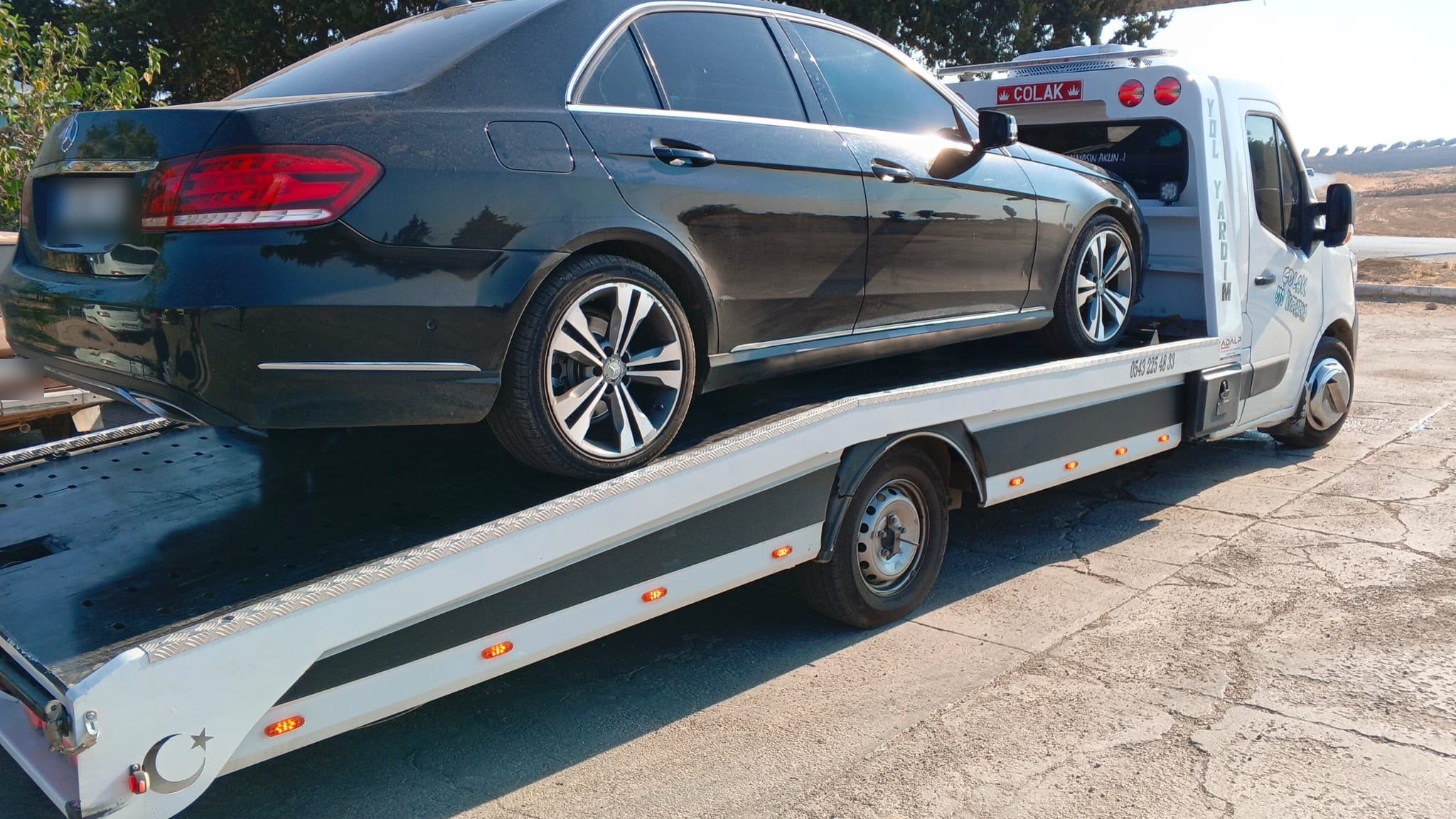 Kasasına siyah Mercedes sedan yüklenmiş Çolak Oto Kurtarma çekicisi, gündüz